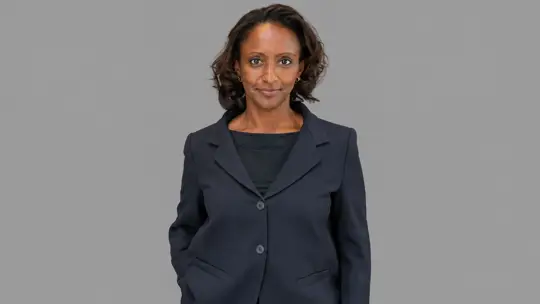 Woman in dark jacket against gray backdrop